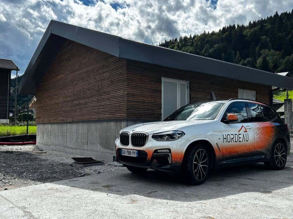 Bâtiment enedis terminé avec bardage bois et toiture acier à morzine avec véhicule hordeau au premier plan