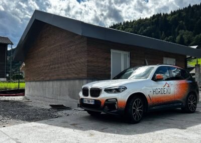 Bâtiment enedis terminé avec bardage bois et toiture acier à morzine avec véhicule hordeau au premier plan