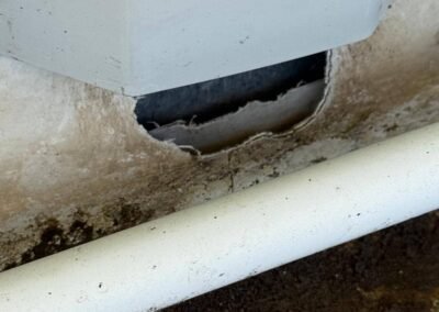 Déchirure membrane pvc en pied de relevé avec infiltration visible sur toiture bâtiment commercial