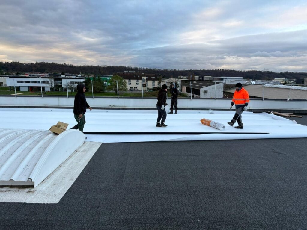 Déploiement d’une membrane tpo blanche sur toiture industrielle avec équipe en intervention