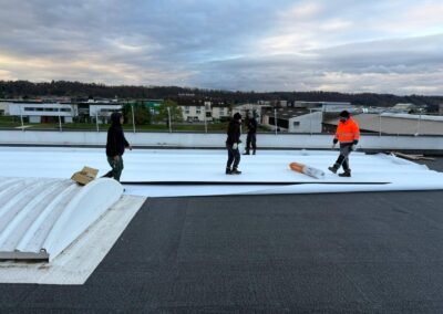 Déploiement d’une membrane tpo blanche sur toiture industrielle avec équipe en intervention
