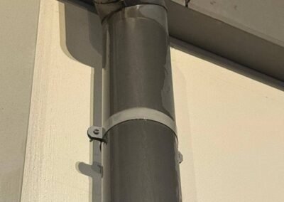 Descente d’eau pluviale avec traces d’humidité et infiltration en façade