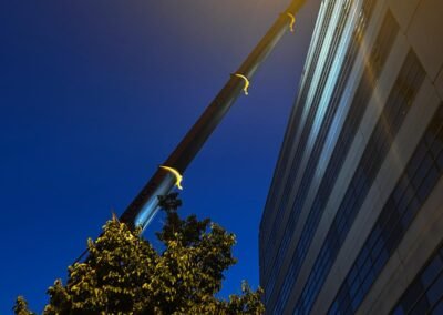Grue de grande hauteur utilisée pour le grutage de nuit des matériaux sur chantier en centre-ville de villeurbanne