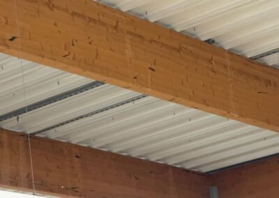 Poutres bois marquées par des infiltrations répétées en sous-face de toiture magasin lidl