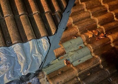 Toiture tuiles avec réparation provisoire et zone d’infiltration au niveau du chenot