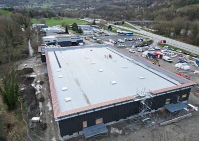 Vue aérienne du chantier de reconstruction du carrefour market à vizille avec toiture neuve et bardage en cours