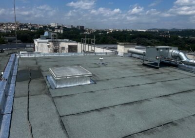 Vue de la toiture bitumineuse rénovée avec lanterneau et équipements techniques à villeurbanne